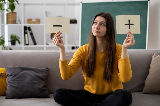 Full shot woman on couch with paper