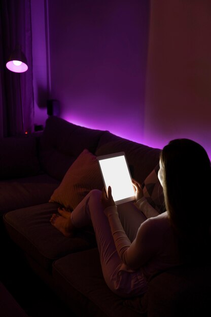 full shot woman on couch with tablet