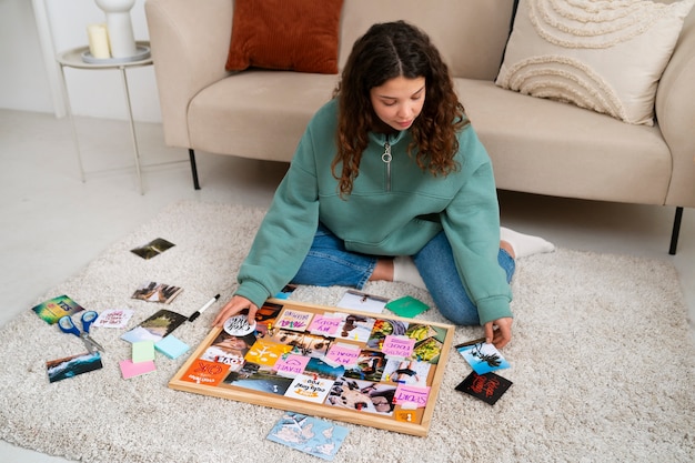 Foto gratuita donna a figura intera che crea una tavola ispiratrice