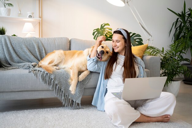 フルショットの女性とかわいい犬の家