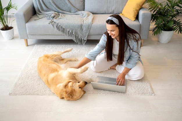 Free photo full shot woman and cute dog inside