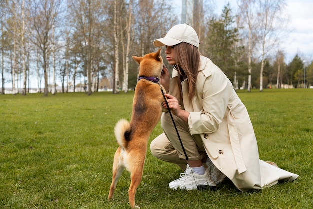 Free photo full shot woman and cute shiba inu dog