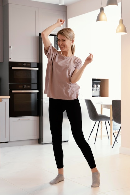 Полный снимок женщина танцует дома