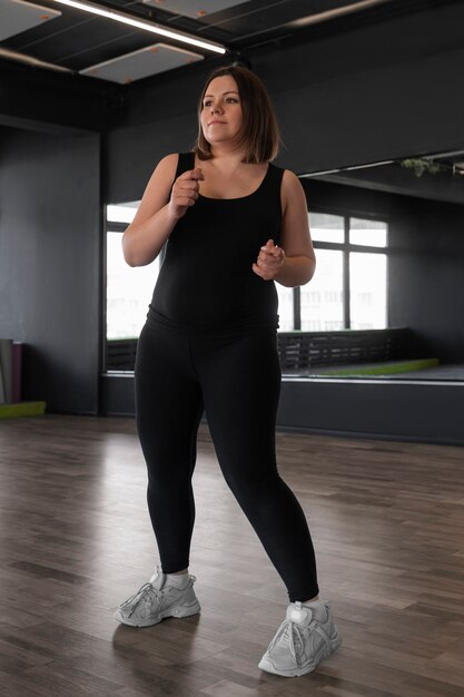 Full shot woman dancing in studio