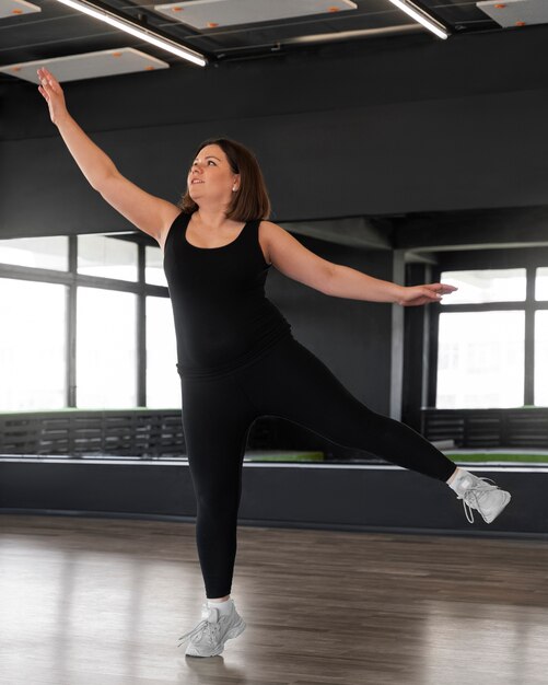 Full shot woman dancing in studio