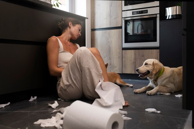 Full shot woman and dog laying on floor