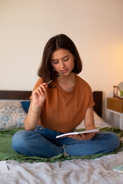 Full shot woman doing creative journaling