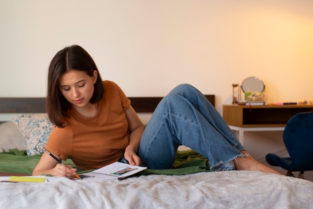 Full shot woman doing creative journaling