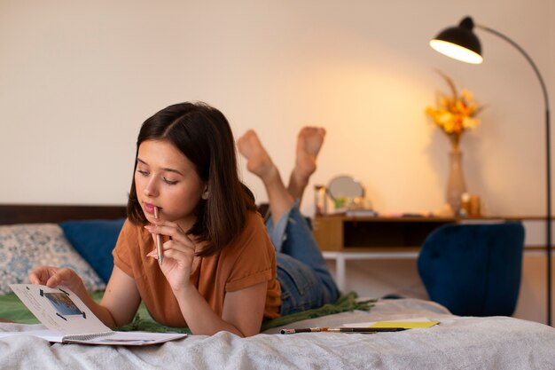 Full shot woman doing creative journaling