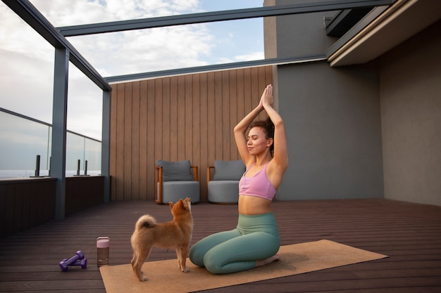 Full shot woman doing sport accompanied by dog