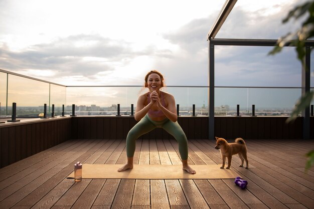 Full shot woman doing sport accompanied by dog