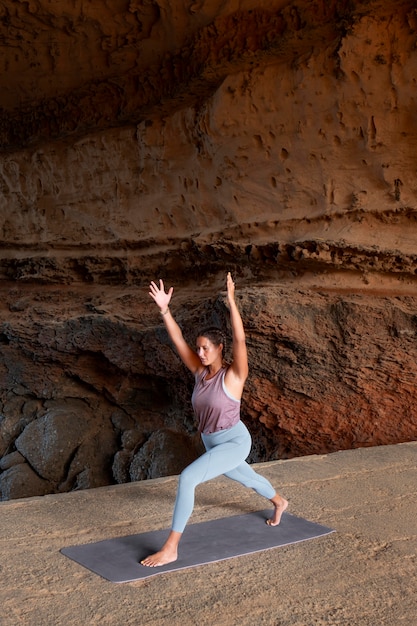 Full shot woman doing sport on mat