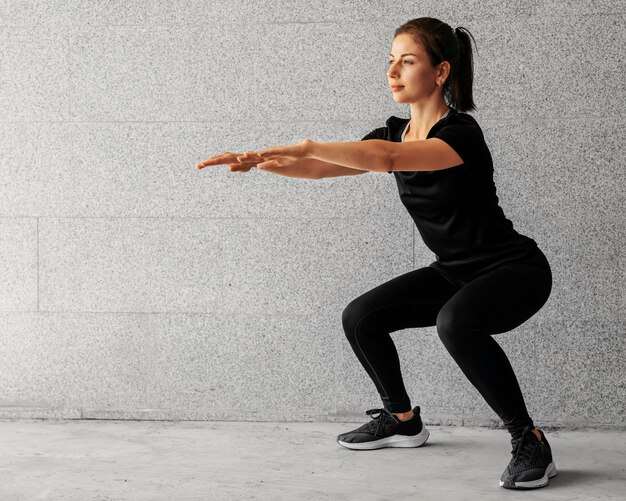 Full shot woman doing squats