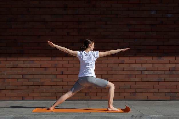 Foto gratuita donna a tutto campo che fa yoga all'aperto