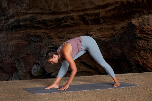 Full shot woman doing yoga pose outside