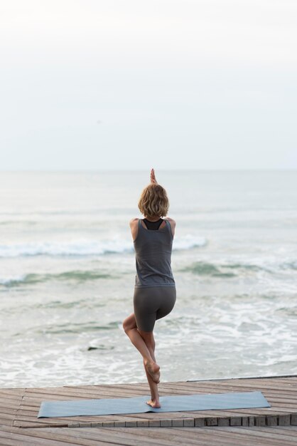 Full shot woman doing yoga pose towards swa