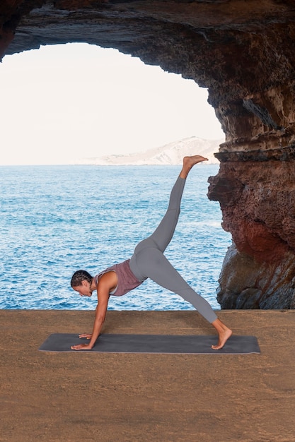 Foto gratuita donna a tutto campo che fa posa yoga