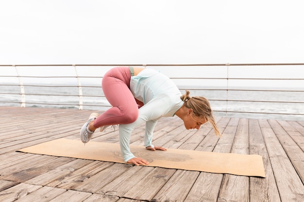 Foto gratuita donna a tutto campo che fa posa yoga