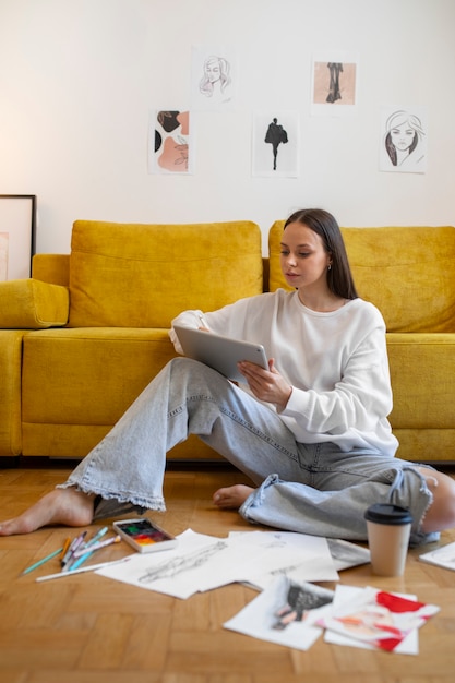 Donna del colpo pieno che assorbe l'ipad