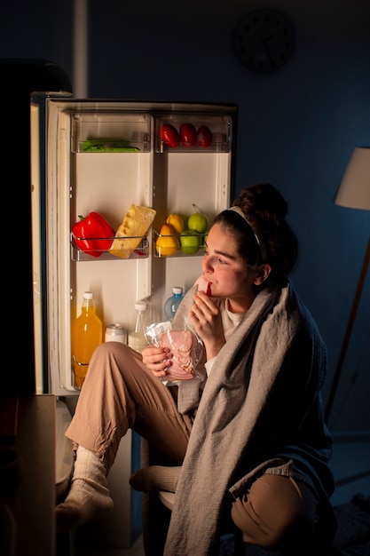 Full shot woman eating at nighttime