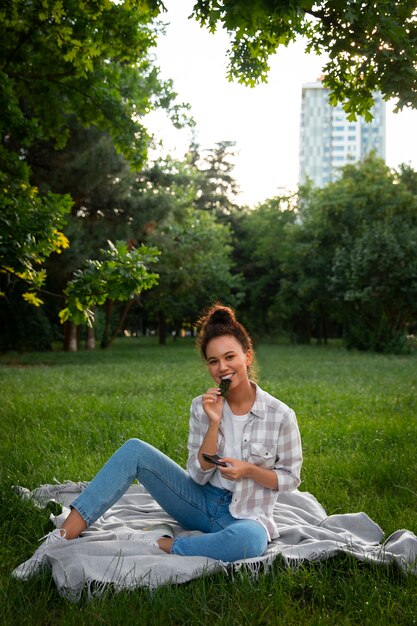 full shot woman  eating seaweed snack