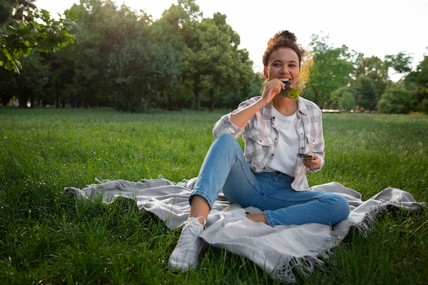 Free photo full shot woman  eating seaweed snack