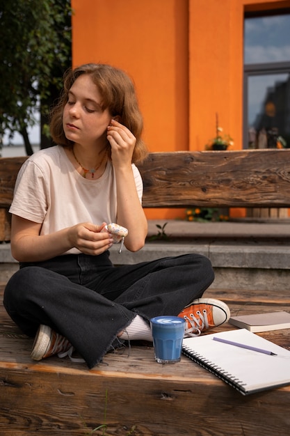 Full shot woman enjoying a blue matcha