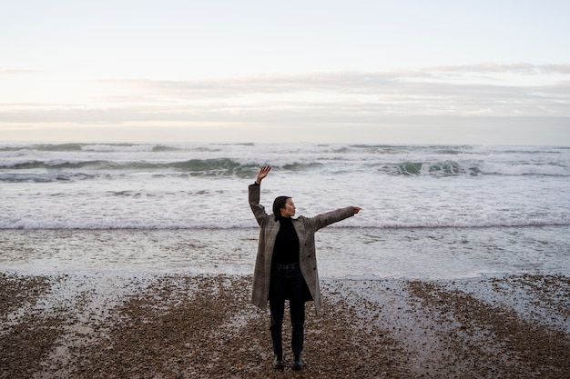 Free photo full shot woman enjoying time at beach