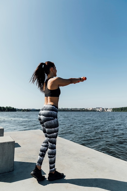 Full shot of woman exercising by the lake