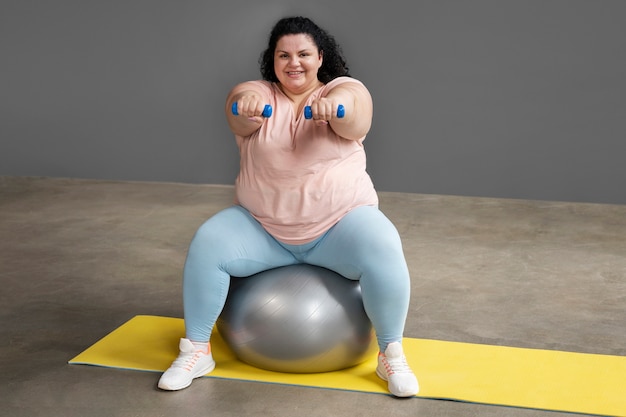 ジムで運動するフルショットの女性