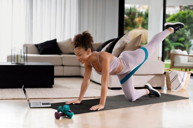 Full shot woman exercising at home