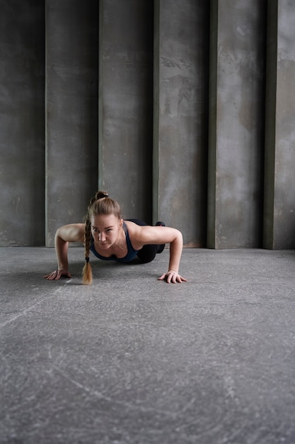 Full shot woman exercising inside