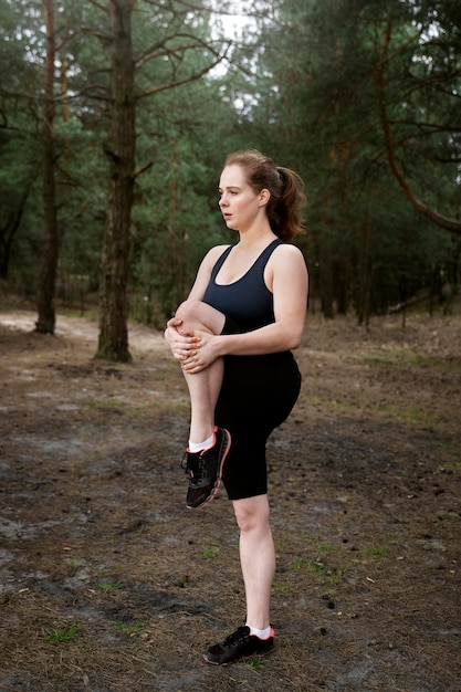 Free photo full shot woman exercising outdoors