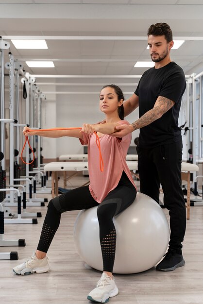 Full shot woman exercising with ball