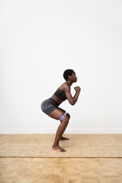 Full shot woman exercising with elastic band