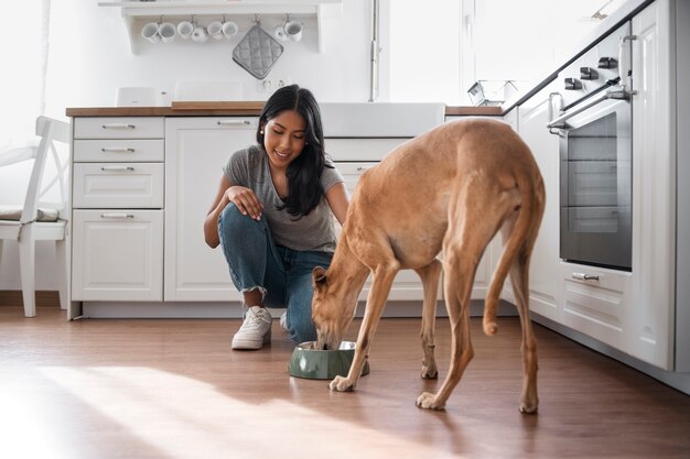 Full shot woman feeding dog