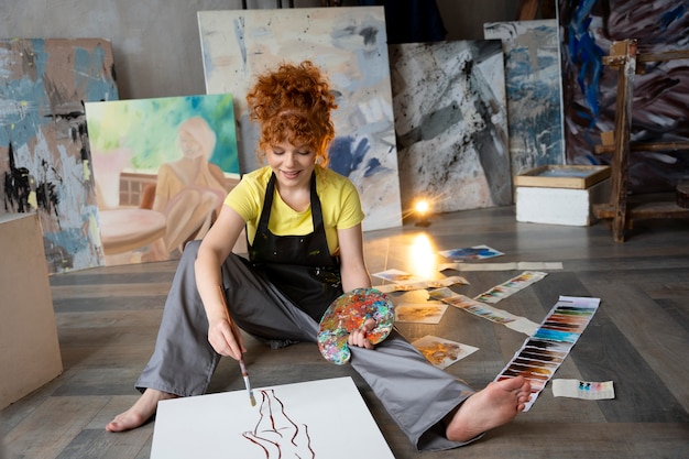 Full shot woman on floor painting