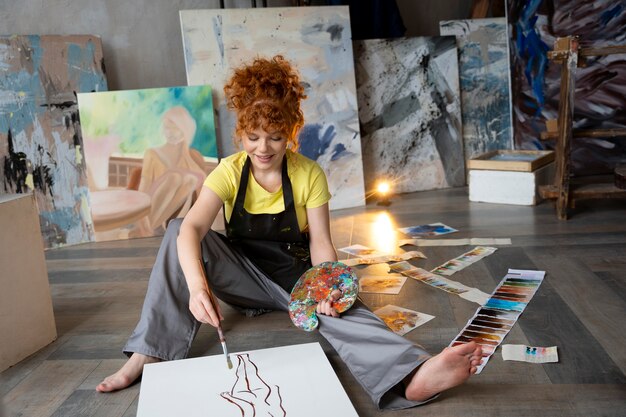 Full shot woman on floor painting