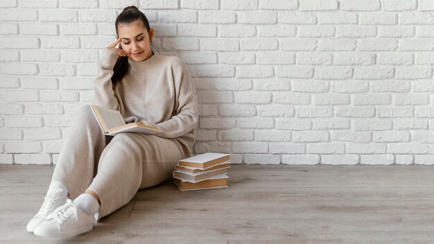 Full shot woman on floor reading