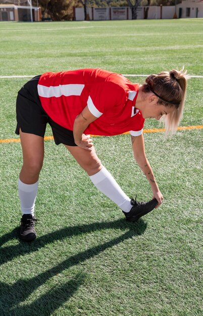 Donna piena del colpo sul campo di calcio che si estende