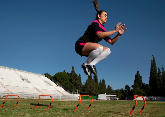 Foto gratuita giocatore di football americano della donna del colpo pieno sul campo