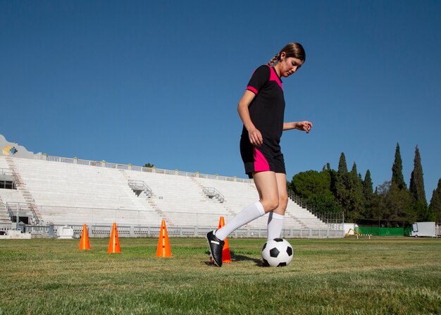 フィールド上のフルショットの女性サッカー選手