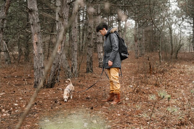 Full shot woman in forest with cute dog