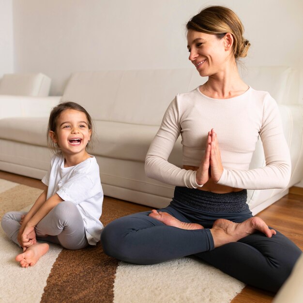 Full shot woman and girl on floor