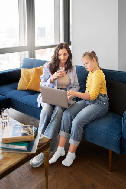 Full shot woman and girl with laptop