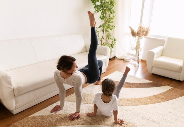 Full shot woman and girl working out at home