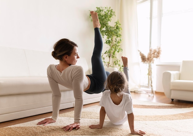 フルショットの女性と女の子が屋内で運動