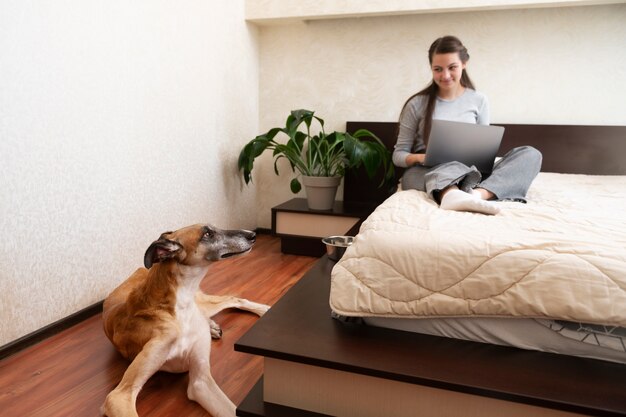 Donna a tutto campo e cane levriero a casa