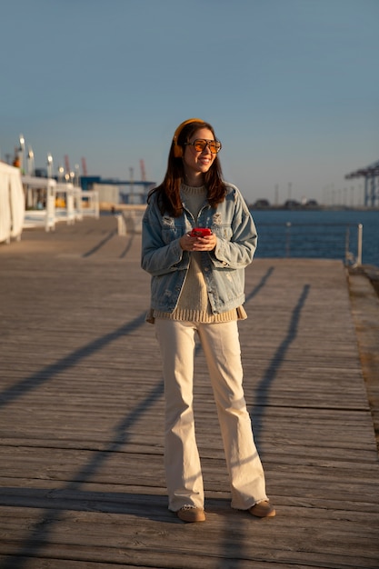 Free photo full shot woman  hanging out on a jetty