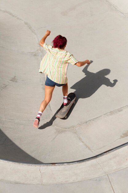 スケートボードで楽しんでいるフルショットの女性
